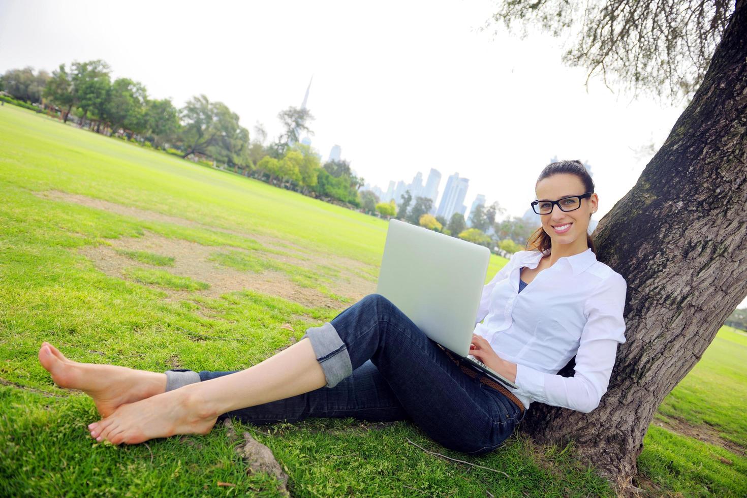 vrouw met laptop in park foto