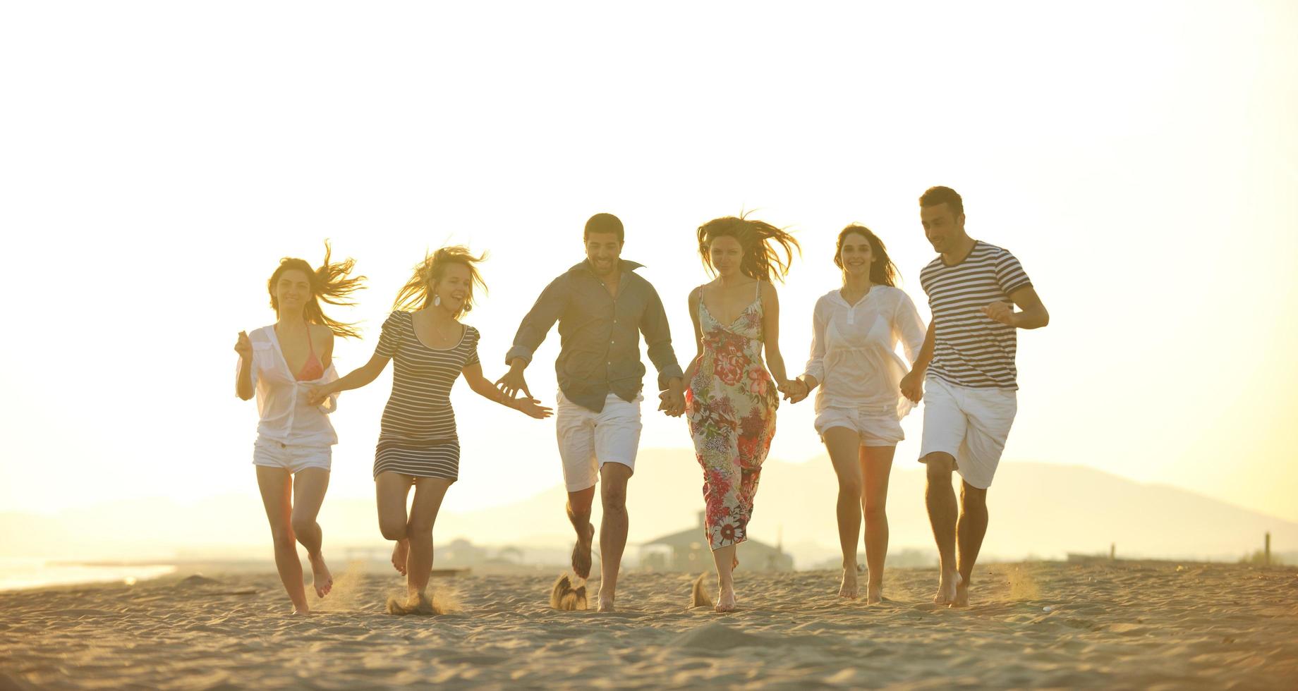 gelukkig jong mensen groep hebben pret Aan strand foto
