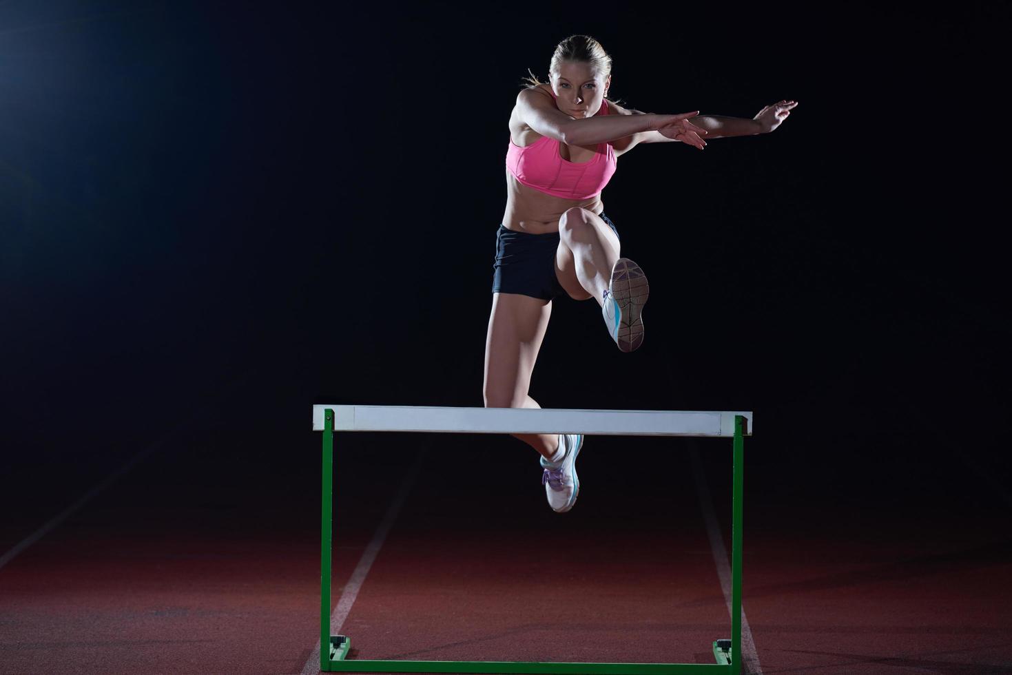 vrouw atleet jumping over- een hindernissen foto