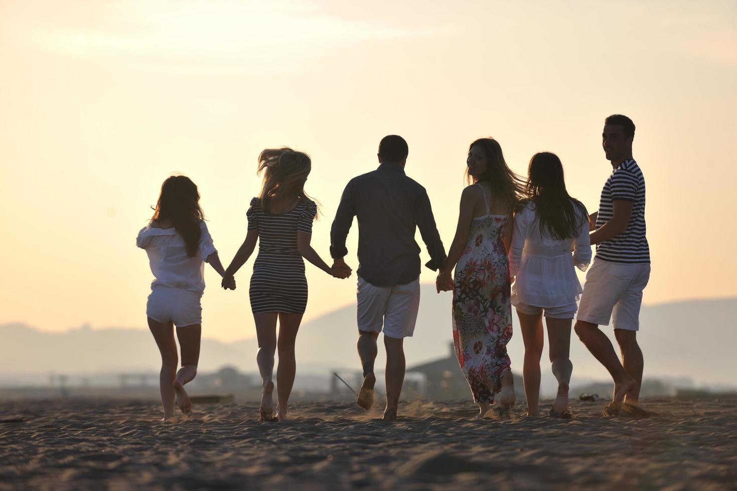 gelukkig jong mensen groep hebben pret Aan strand foto