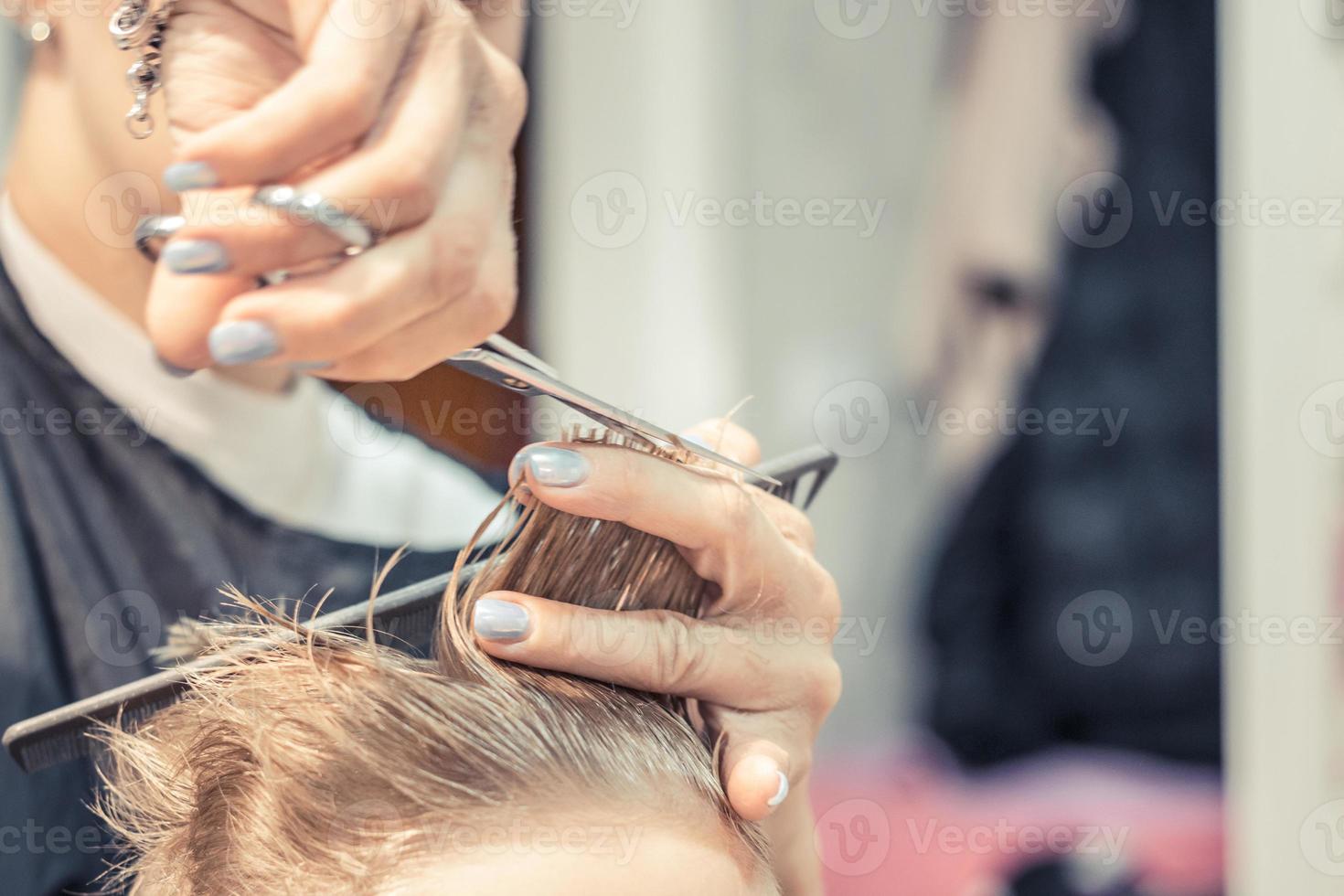 dichtbij omhoog van haar stylist snijdend jongens haar. foto