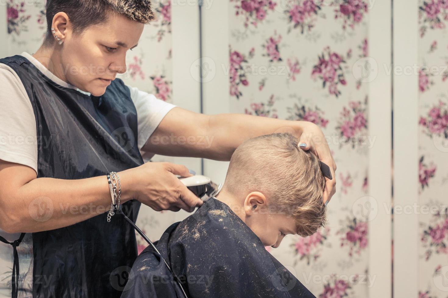 klein kind krijgen een kapsel door vrouw kapper. foto