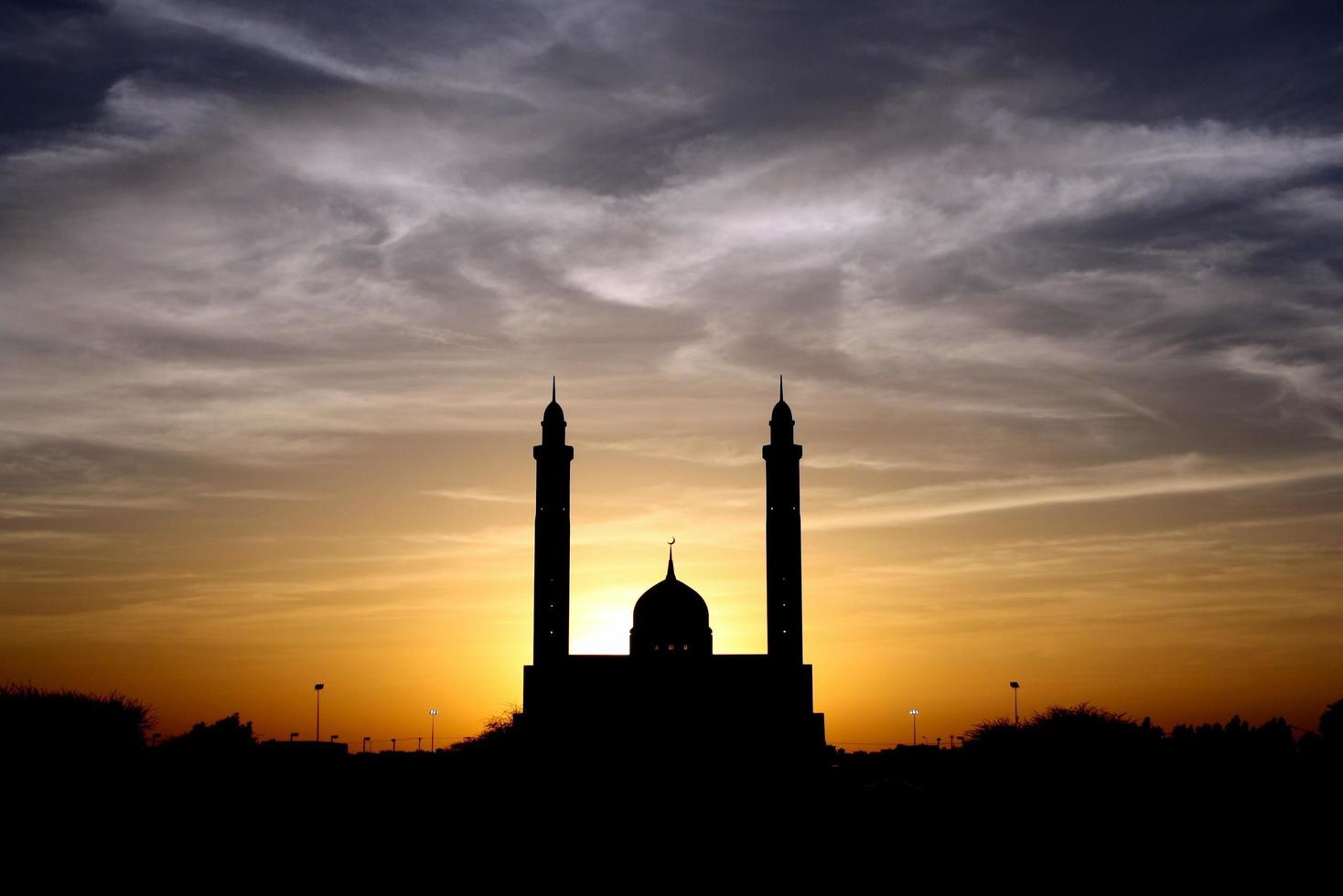 silhouet van moskee onder bewolkte hemel foto