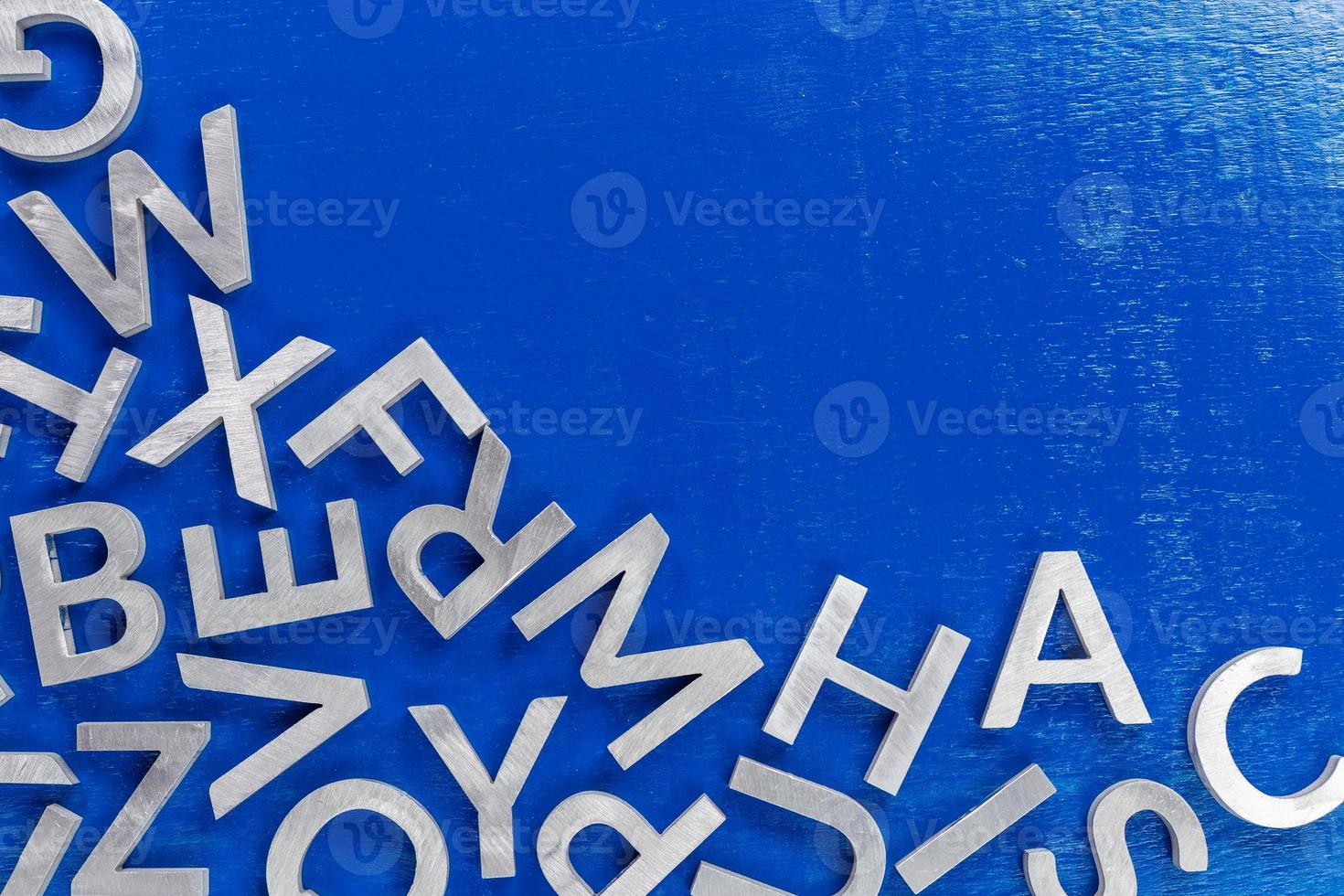 abstract vlak achtergrond van zilver metaal alfabet tekens Aan blauw achtergrond met voor de helft van kader vulling en copyspace foto