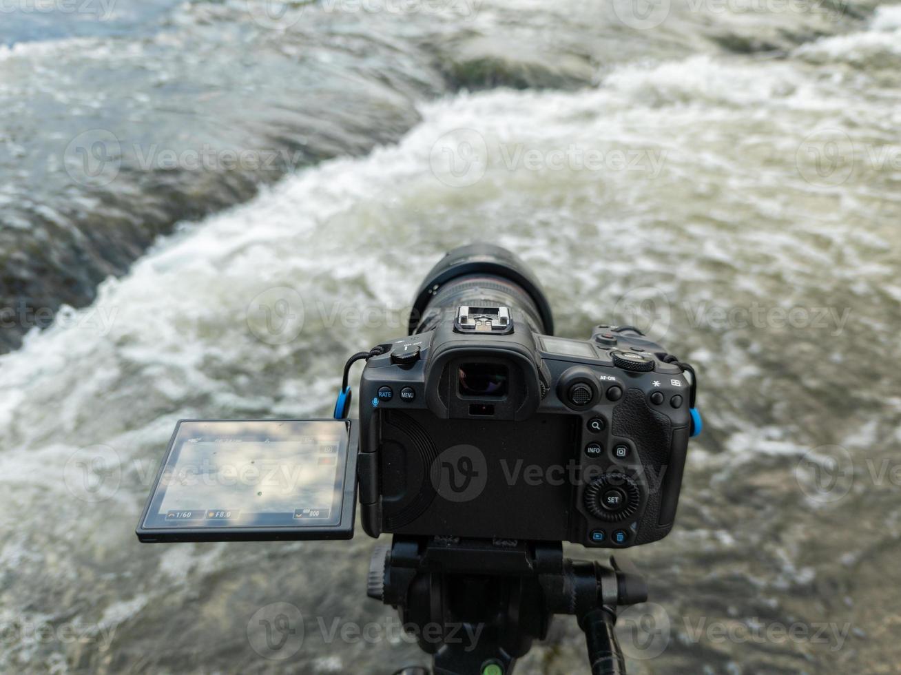 modern zwart digitaal spiegelloos camera met flip-screen Aan statief vastleggen streaming water, detailopname foto