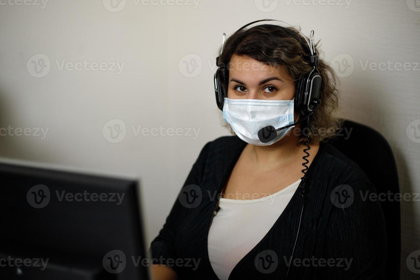 een telefoontje centrum middel werken Aan de ondersteuning hotline in de kantoor, vervelend een masker en handschoenen. de telefoontje centrum operator is pratend naar de klant. foto