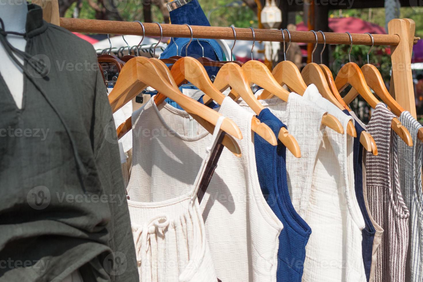 kleren rekken met katoen overgooiers Aan hangers. vitrine met kleren Aan straat markt. foto