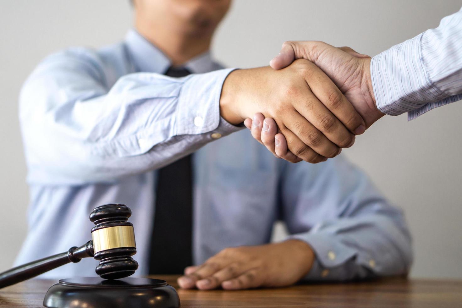 handdruk na overleg tussen een mannelijke advocaat en cliënt foto