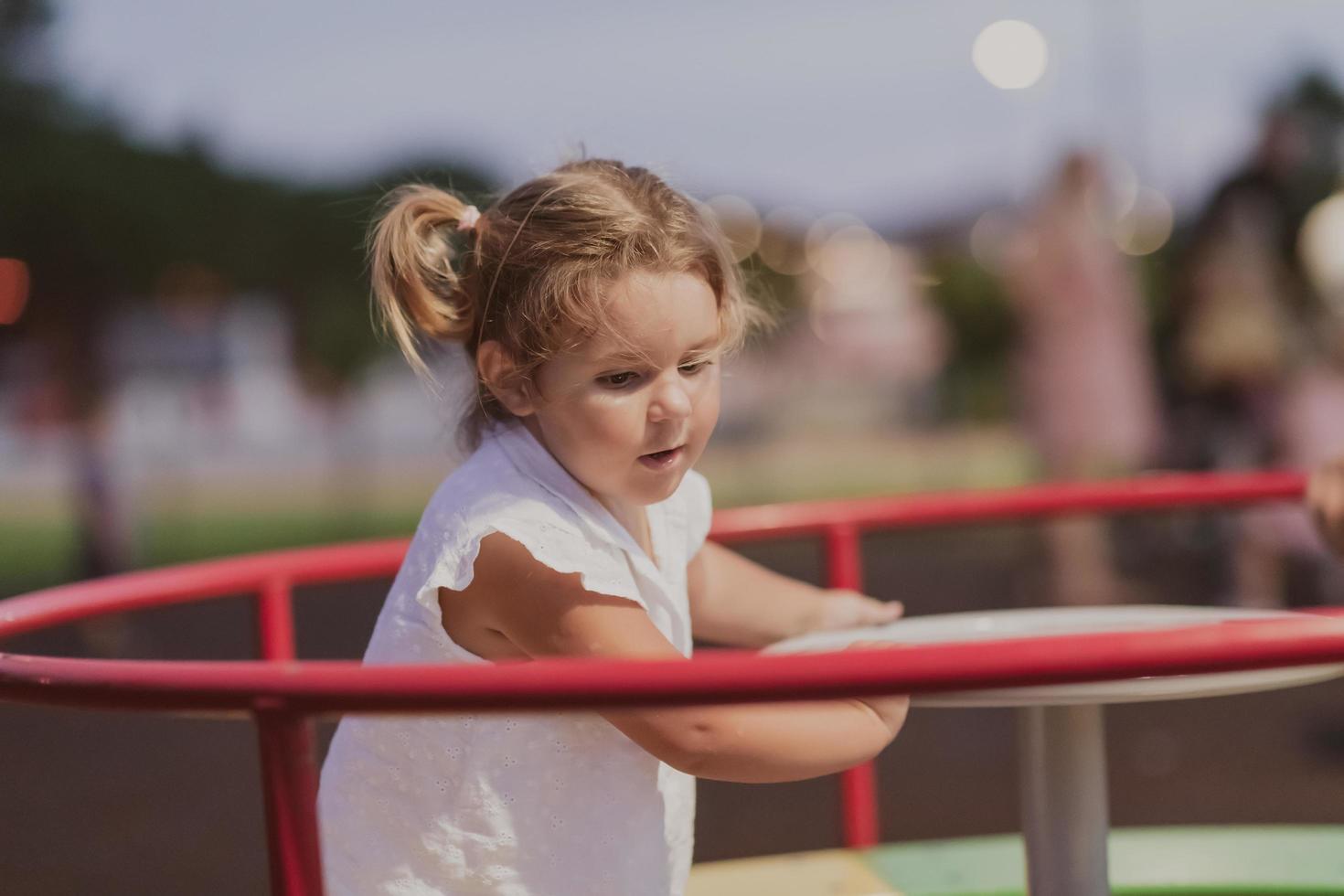 een weinig meisje in modern zomer kleren spelen in de park in zomer. selectief focus foto