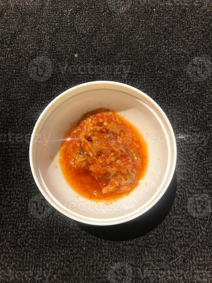 Chili saus in een wit houder foto