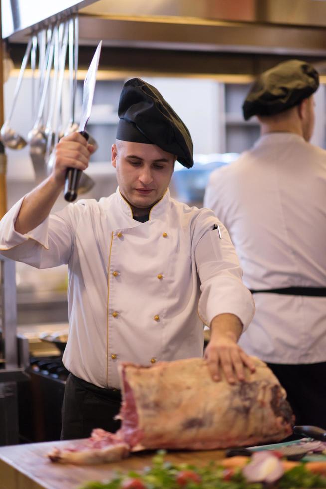 chef snijdend groot stuk van rundvlees foto