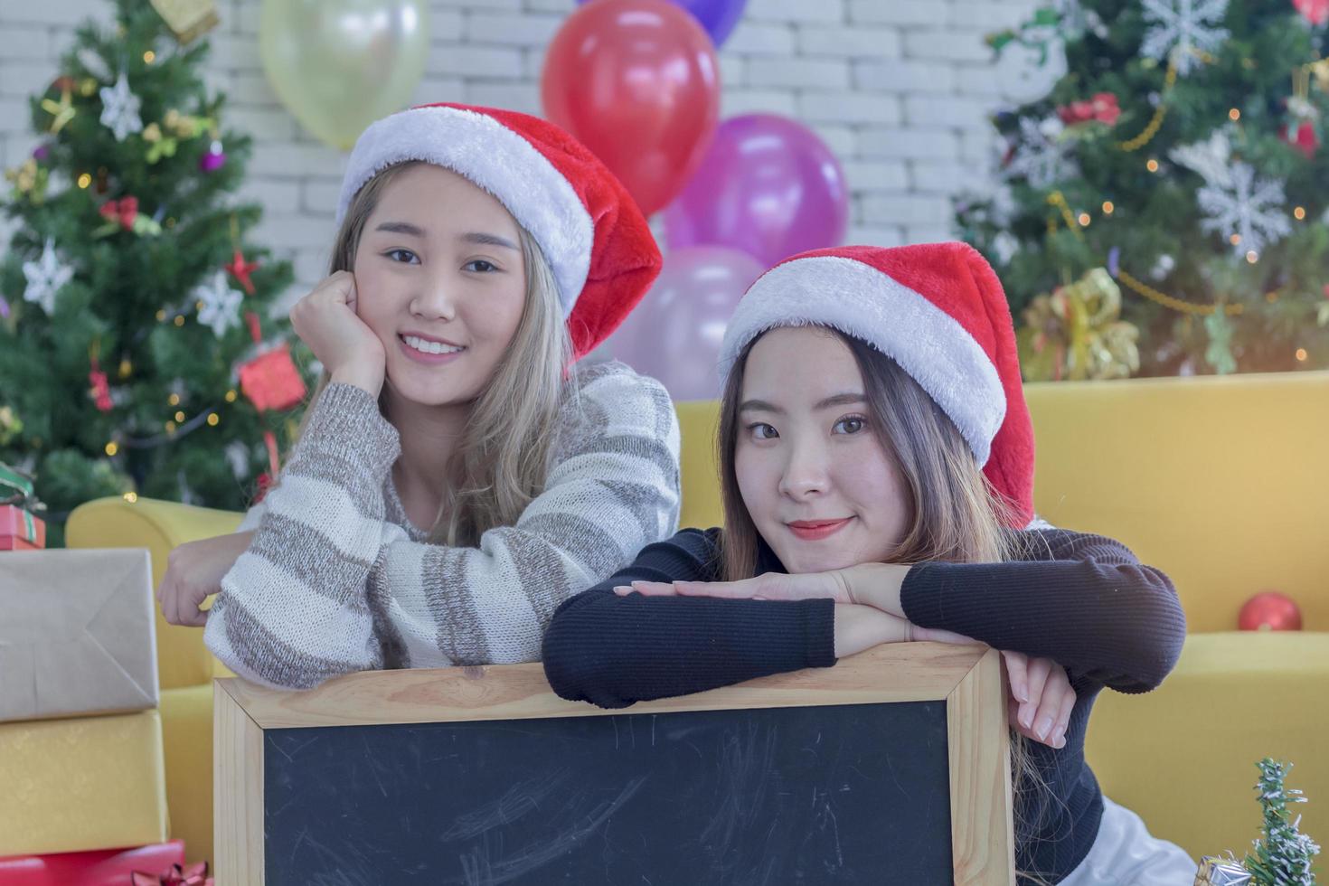 twee vrouwen poseren met santa hoeden foto