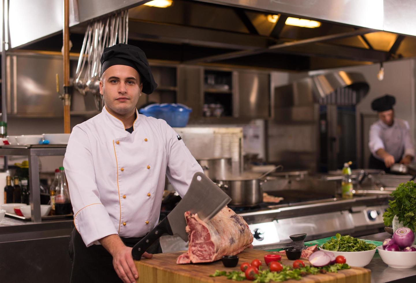 chef snijdend groot stuk van rundvlees foto