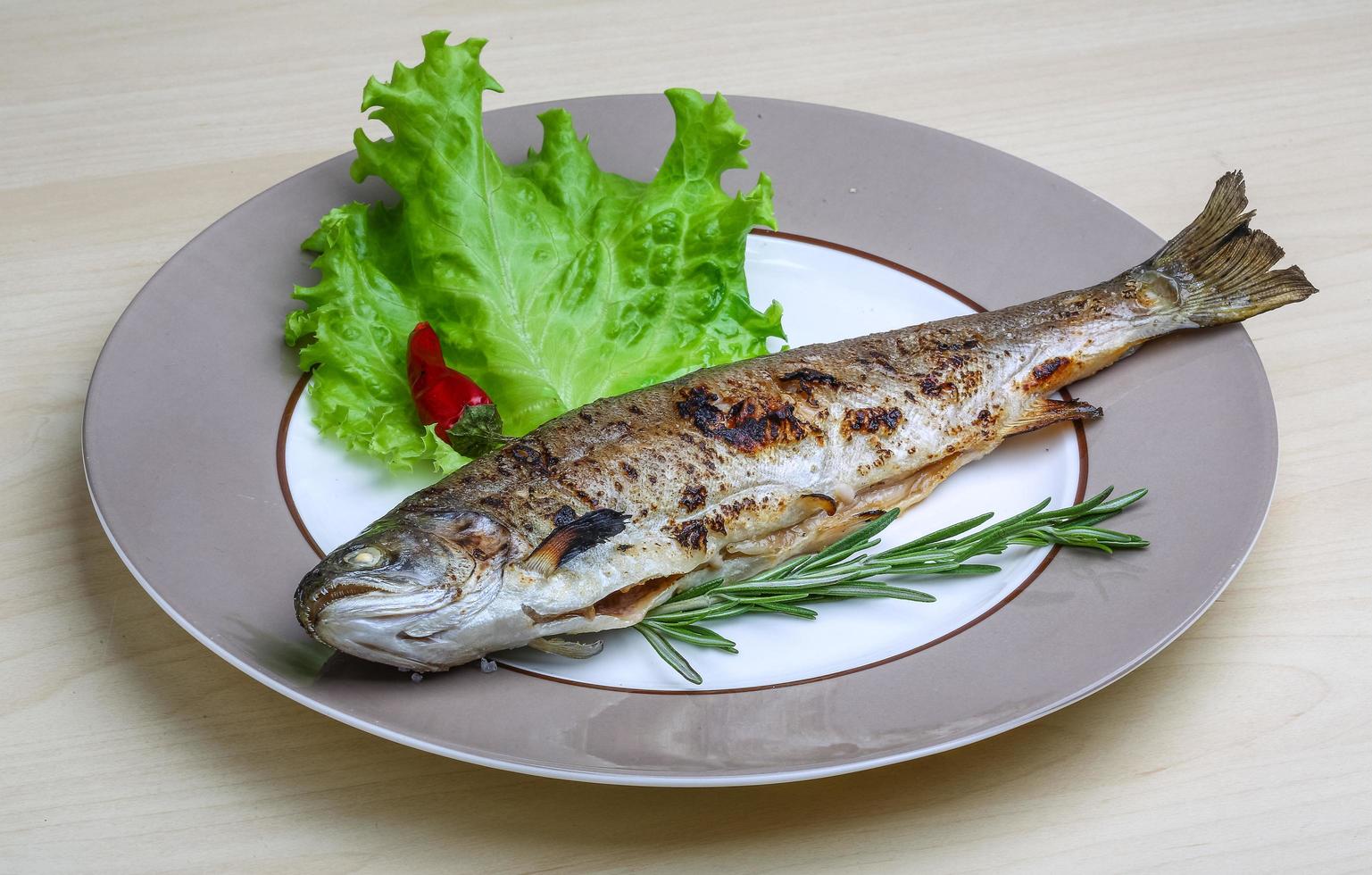 gegrilde forel op de plaat en houten achtergrond foto