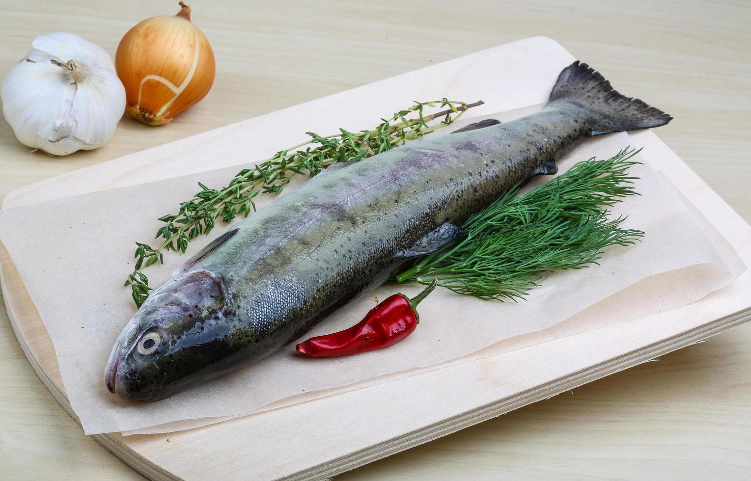 rauw forel Aan houten bord en houten achtergrond foto