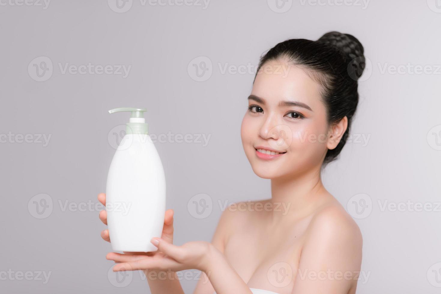 mooi Aziatisch vrouw Holding fles met hydraterend lotion foto