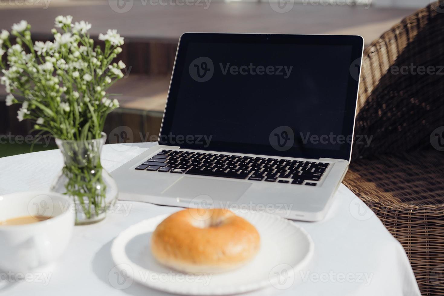 laptop, brood en cafe in koffie winkel foto