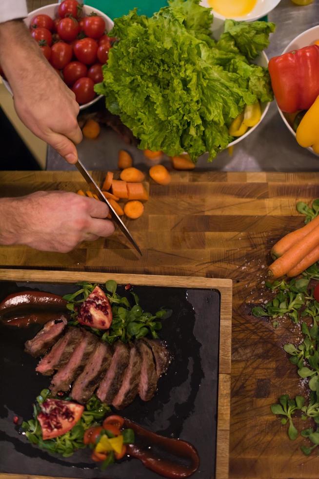 top visie van chef handen voorbereidingen treffen rundvlees steak foto