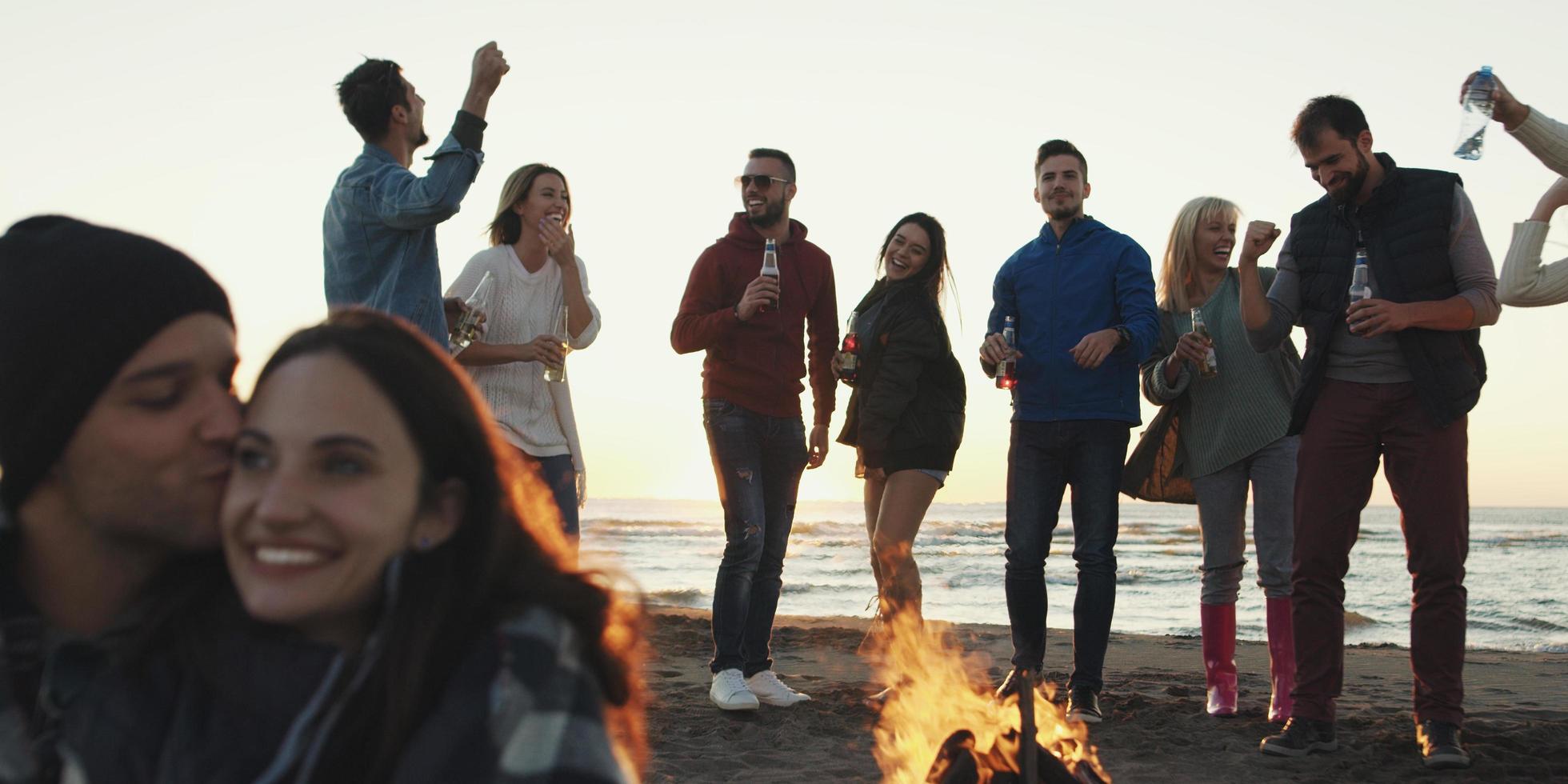 vrienden hebben pret Bij strand Aan herfst dag foto