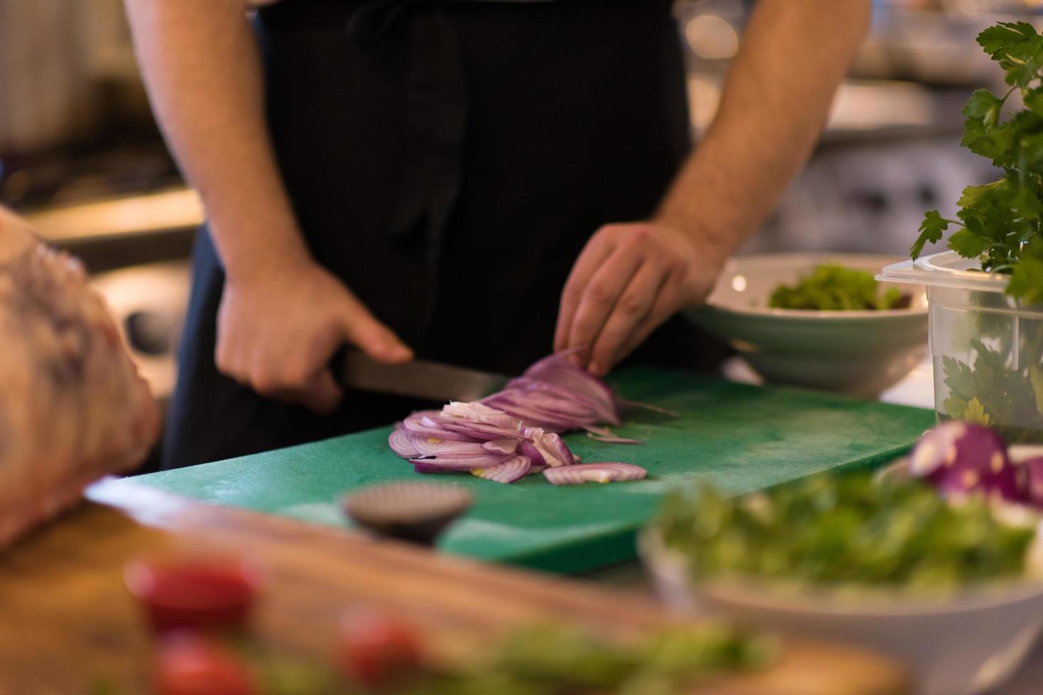 chef handen snijdend de ui met mes foto