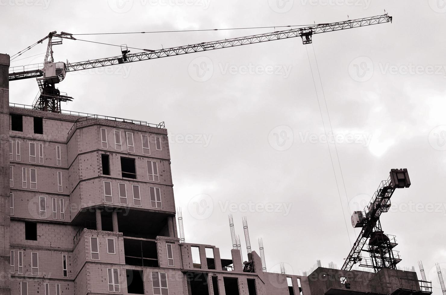werken hoog kranen binnen plaats voor met hoog gebouwen onder bouw tegen een Doorzichtig blauw lucht. kraan en gebouw werken voortgang. retro toon foto
