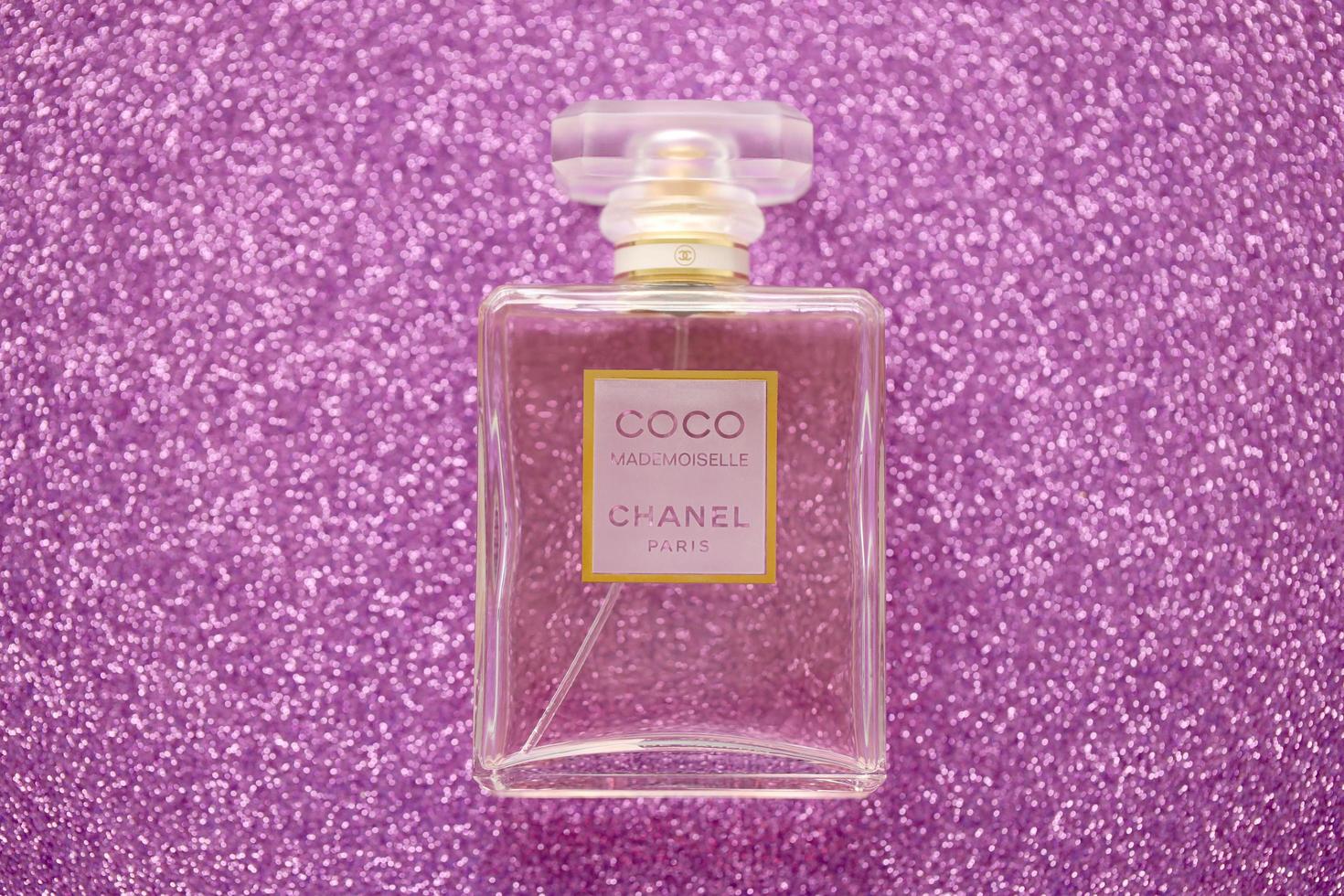 ternopil, Oekraïne - september 2, 2022 kokosnoot mademoiselle chanel Parijs wereldwijd beroemd Frans parfum fles Aan glimmend schitteren achtergrond in Purper kleuren foto