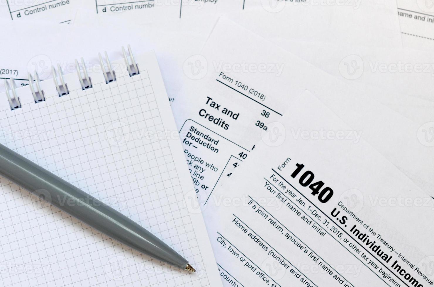 de pen en notitieboekje is leugens Aan de belasting het formulier 1040 ons individu inkomen belasting opbrengst. de tijd naar betalen belastingen foto