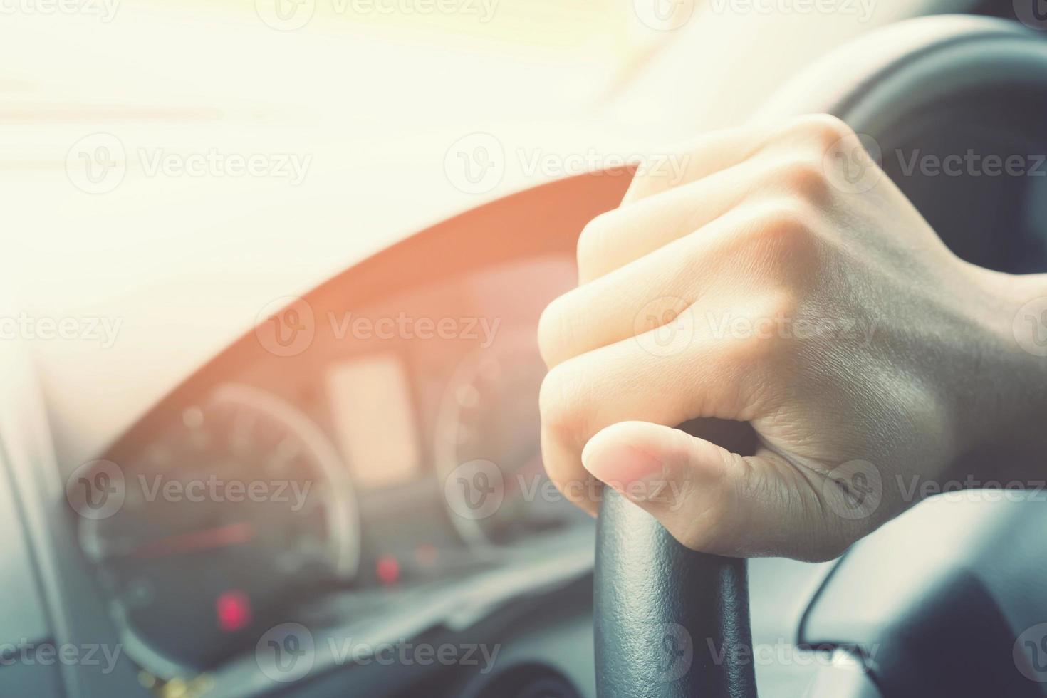 close-up van de hand houden stuurwiel jonge vrouw besturen van een auto rijden op de weg. chauffeur reis van reizen. foto
