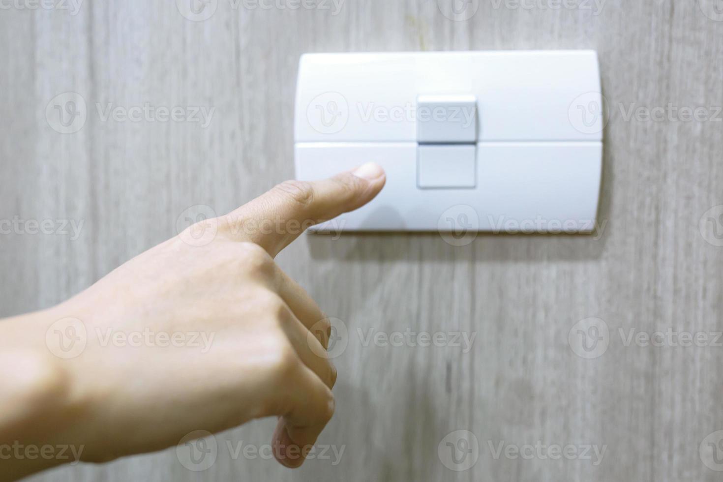 beurt uit de licht, dichtbij omhoog vinger Mens hand- is sluitend de macht schakelaar met muur Bij huis naar opslaan energie. verminderen globaal opwarming. foto