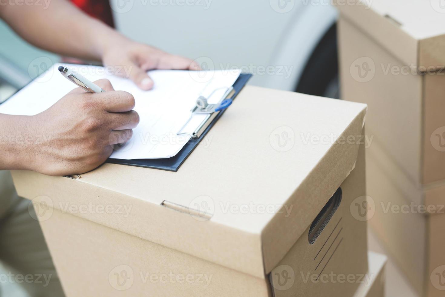 mensen Mens ondertekening bon ontvangen pakket pakket levering Mens van een pakket door een onderhoud. en dichtbij omhoog hand- klant accepteren een levering van dozen post. foto