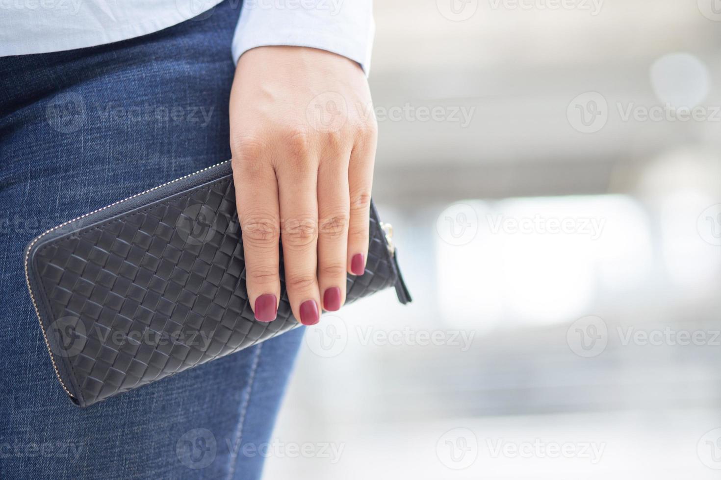 vrouw Holding een mode portemonnee, ze is boodschappen doen Bij een afdeling op te slaan. foto