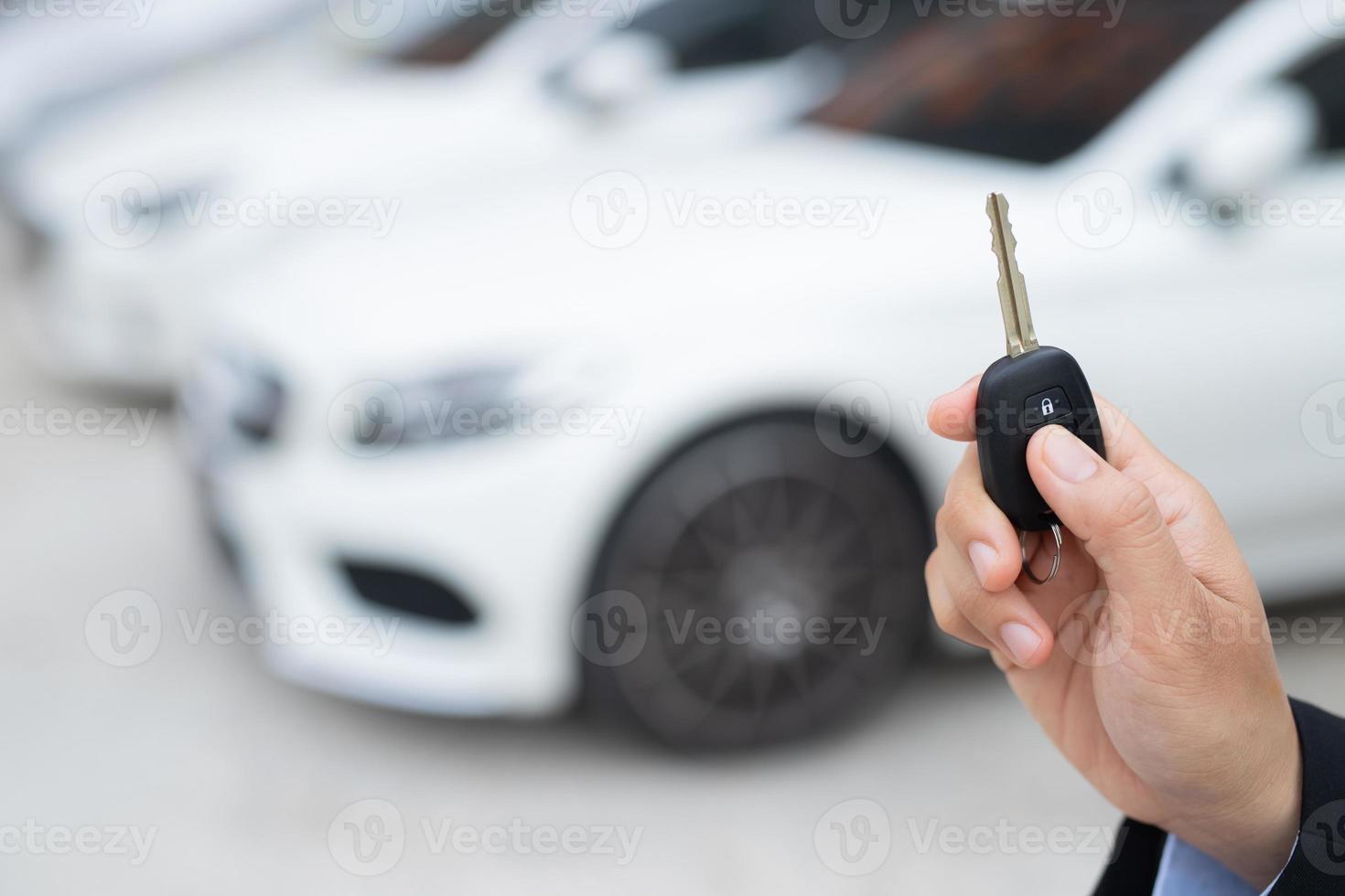 verkoper is draag- de auto sleutels geleverd naar de klant Bij de toonzaal met een laag interesseren bieden. speciaal Promotie foto