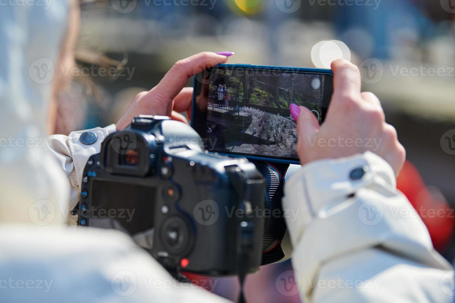 vrouw videograaf filmen Aan dslr camera en smartphone buitenshuis evenement, video foto bloggen