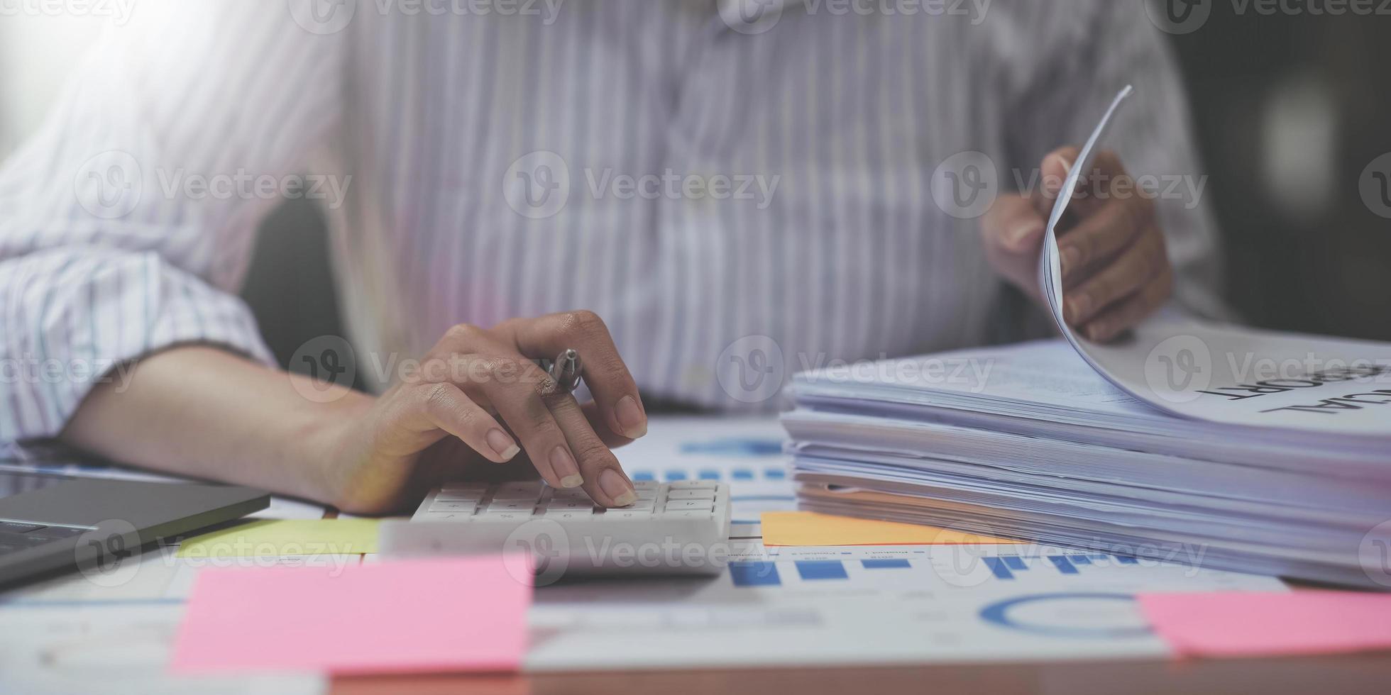 bedrijf vrouw tellen Aan rekenmachine en Holding documenten in handen detailopname. boekhouding concept foto