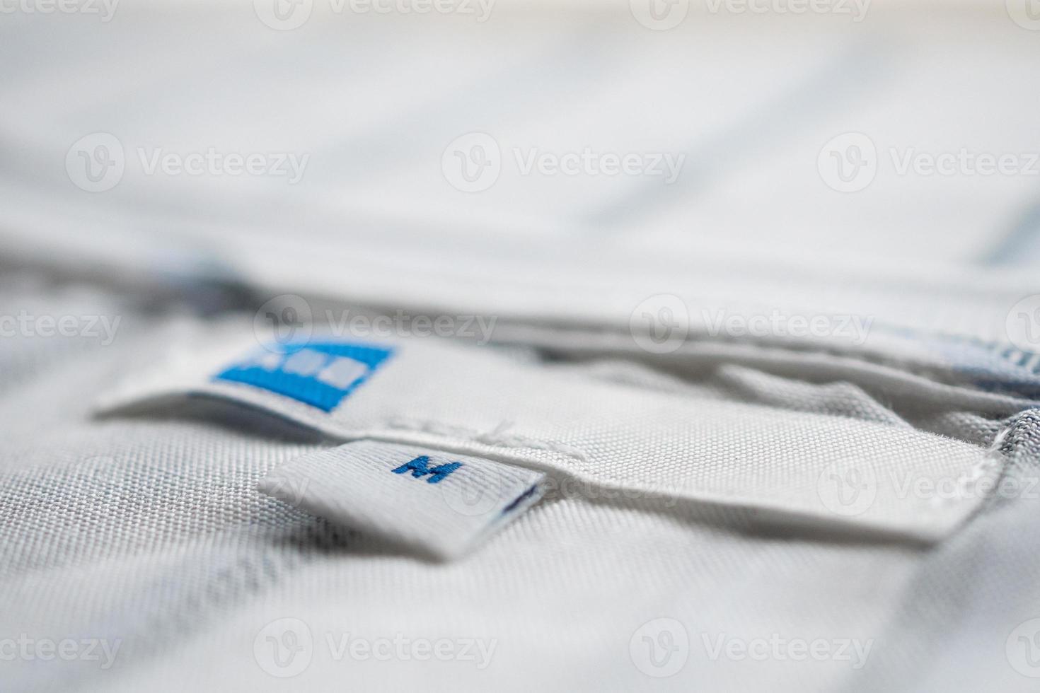 wit kleren etiket dichtbij omhoog Aan nieuw overhemd foto