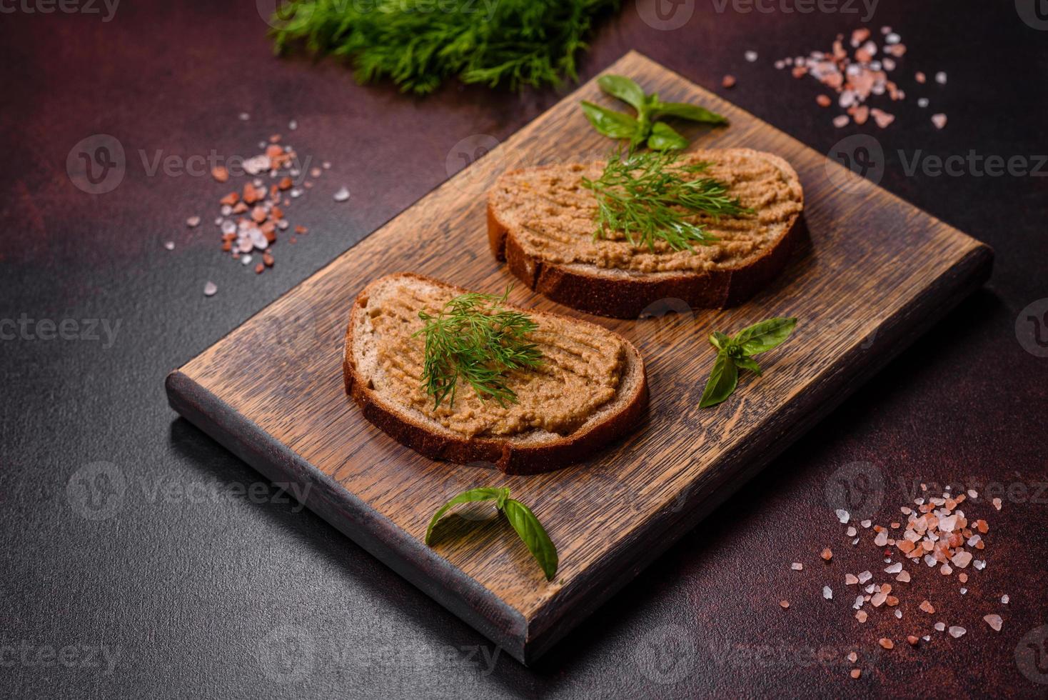 eigengemaakt vlees tussendoortje lever paté met geroosterd brood Aan een donker beton achtergrond foto