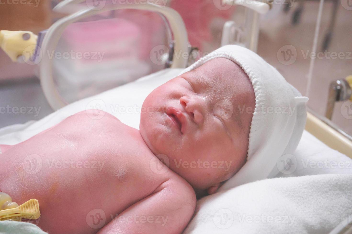 nieuw geboren baby zuigeling slaap in de incubator Bij ziekenhuis foto