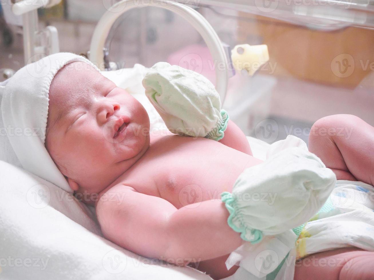 nieuw geboren baby zuigeling slaap in de incubator Bij ziekenhuis foto