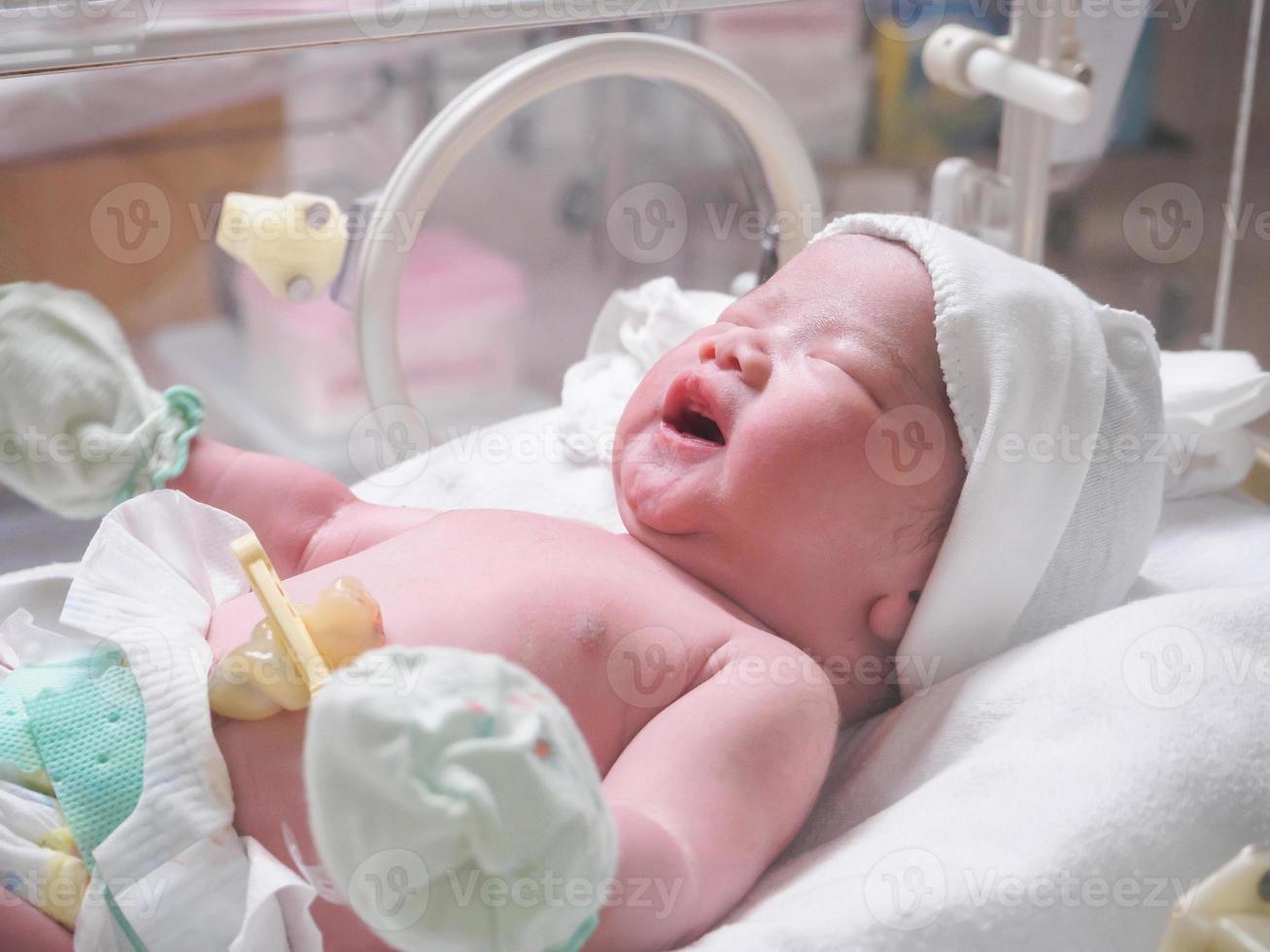 nieuw geboren baby zuigeling slaap in de incubator Bij ziekenhuis foto