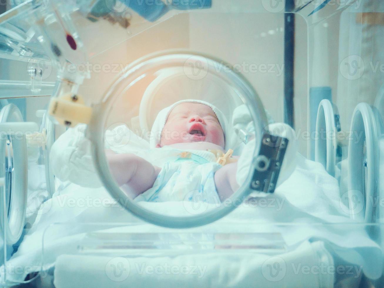 pasgeboren baby meisje binnen incubator in ziekenhuis post levering kamer foto