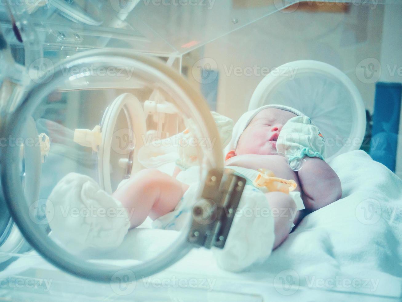 pasgeboren baby binnen incubator in ziekenhuis post levering kamer foto