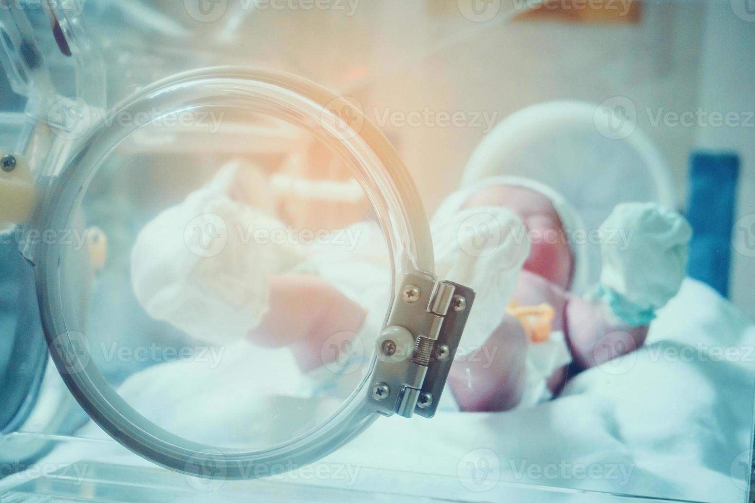 pasgeboren baby binnen incubator in ziekenhuis post levering kamer foto