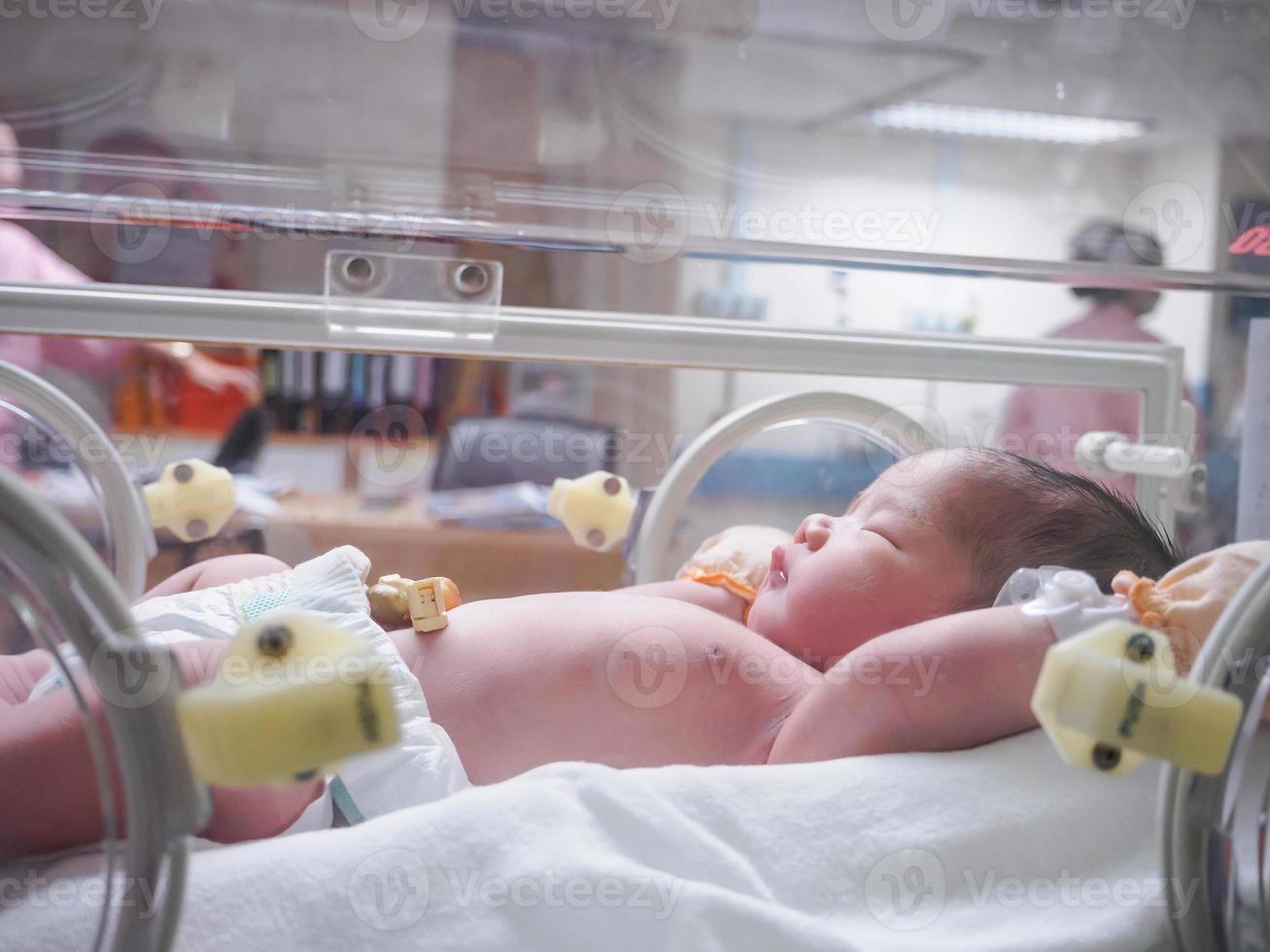 pasgeboren baby meisje binnen incubator in ziekenhuis post levering kamer foto