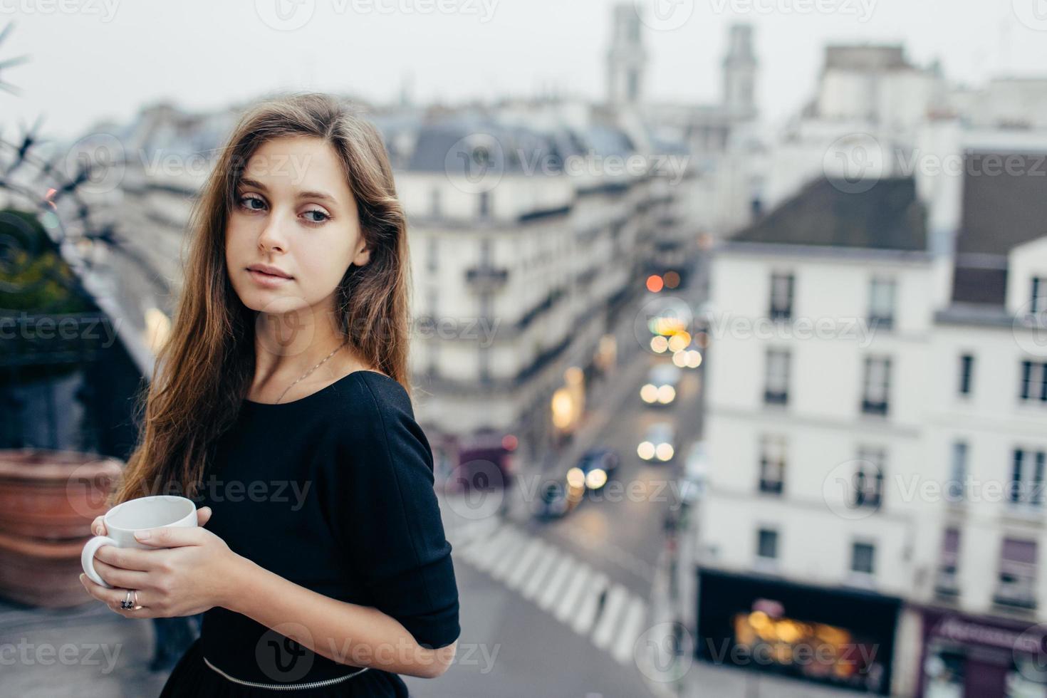 dromerig vrouw met mok Aan balkon foto