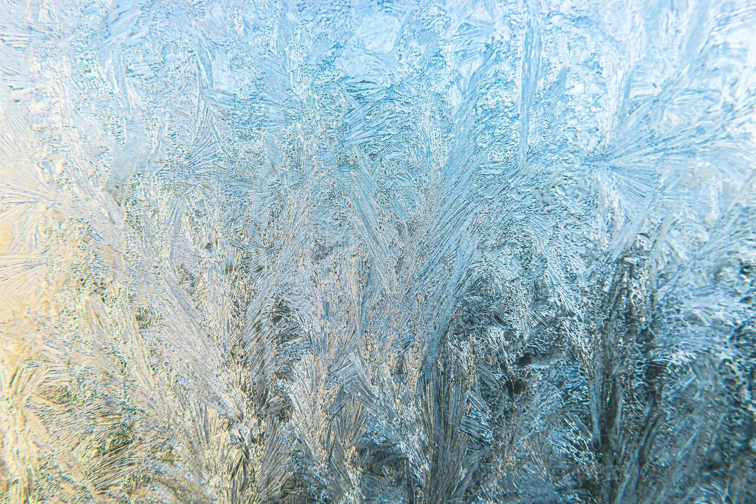 bevroren wintervenster met glanzende ijsvorstpatroontextuur. kerst wonder symbool, abstracte achtergrond. extreme noorden lage temperatuur, natuurlijke ijssneeuw op ijzig glas, koel winterweer buiten. foto