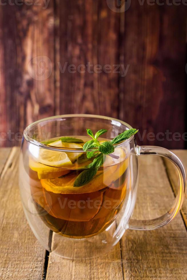 thee met citroen en munt in transparant beker. alternatief geneesmiddel. heet drinken voor ontspanning. foto