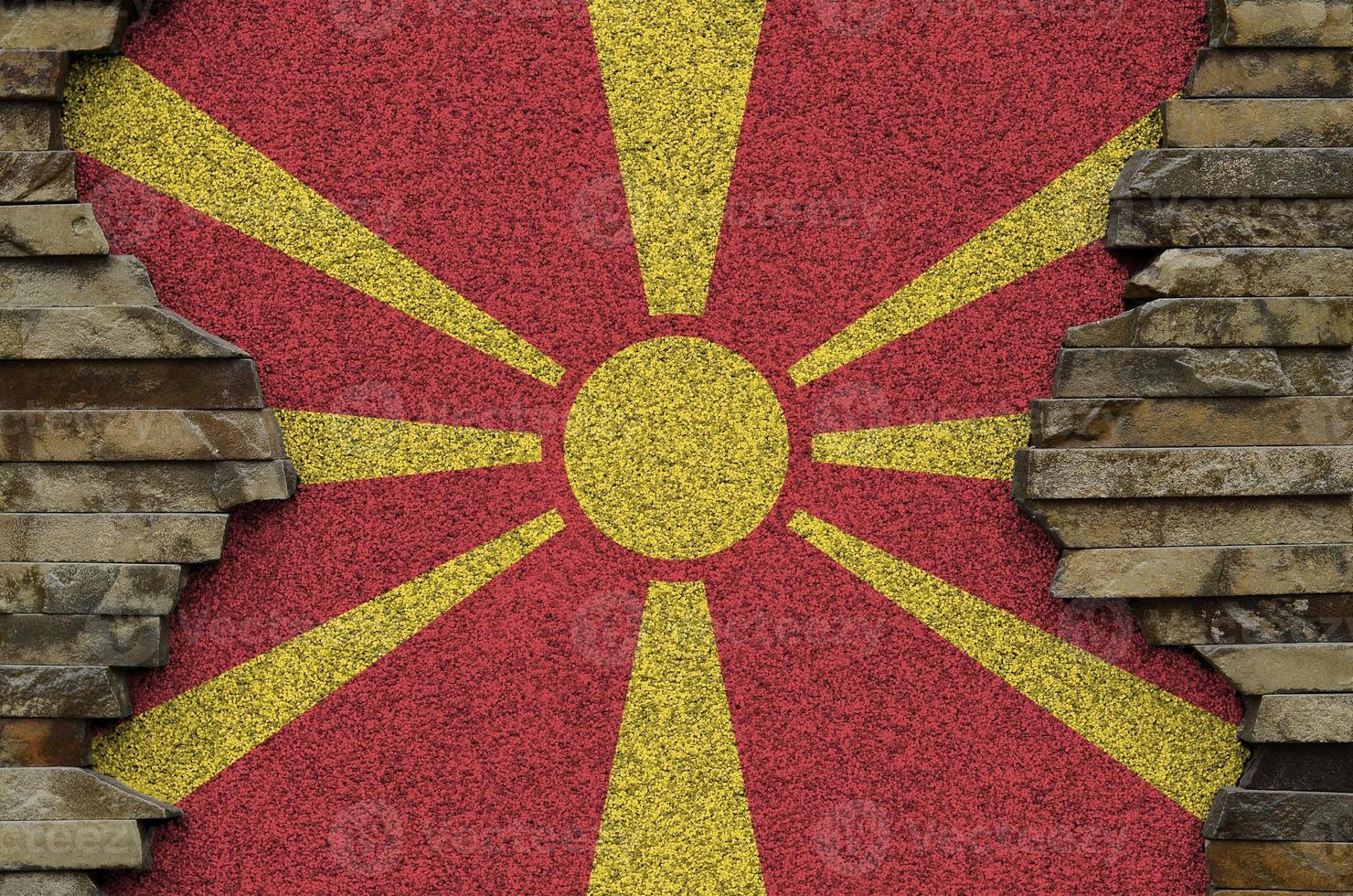 Macedonië vlag afgebeeld in verf kleuren Aan oud steen muur detailopname. getextureerde banier Aan rots muur achtergrond foto