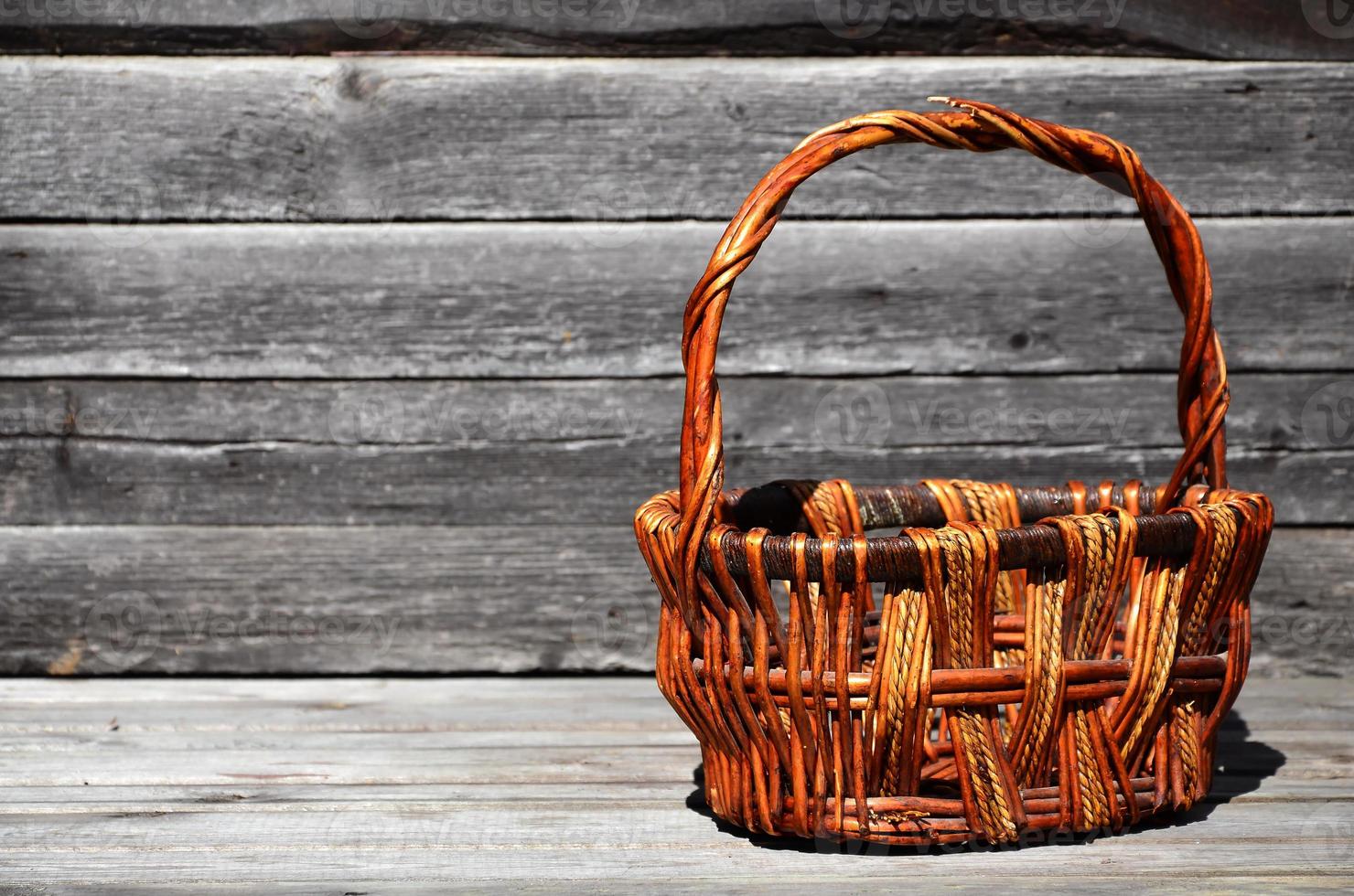 een leeg rieten mand van houten staven leugens Aan een houten oppervlakte foto