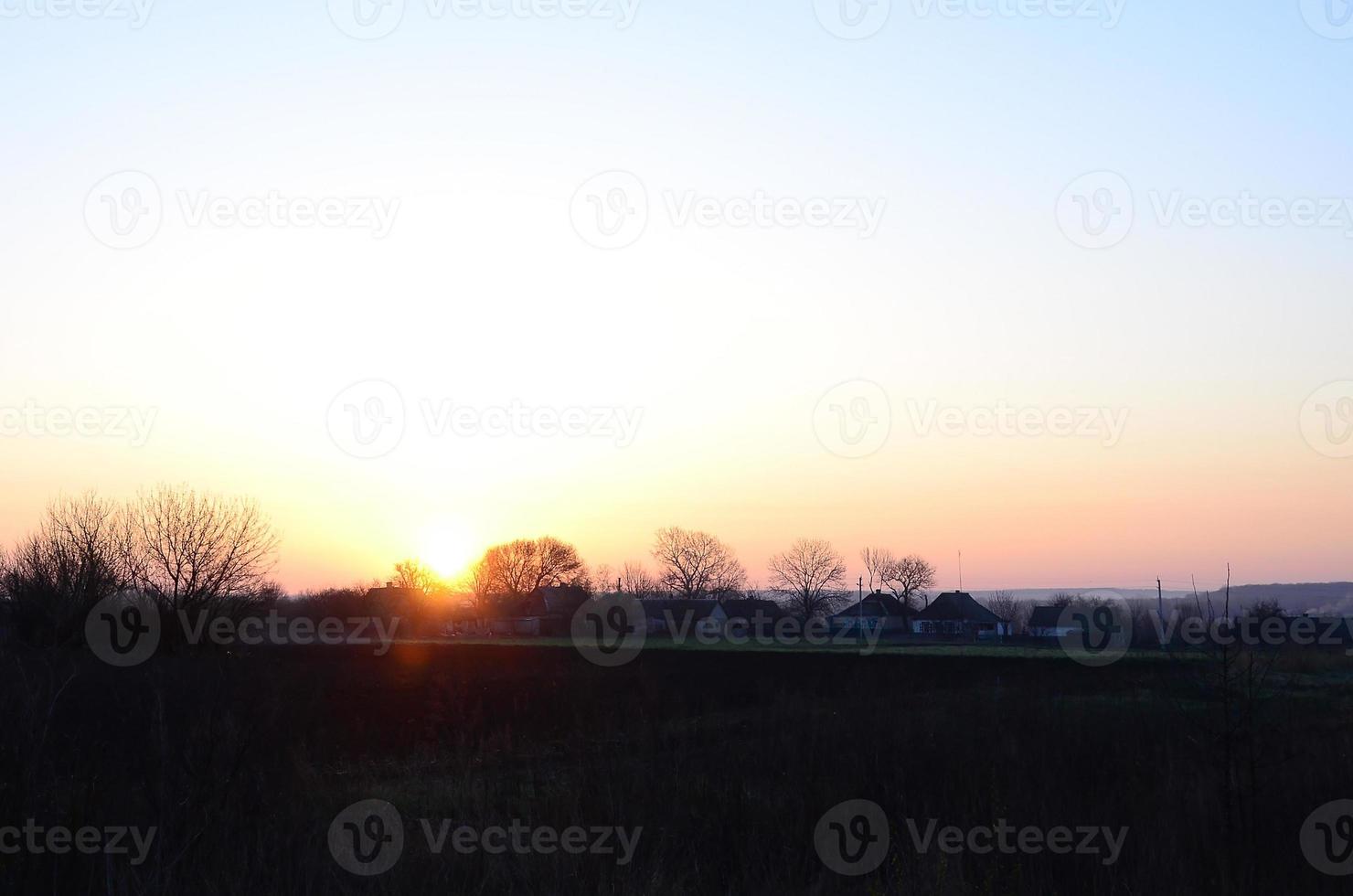 dageraad in de dorp. zonsopkomst in de buitenwijk landschap foto