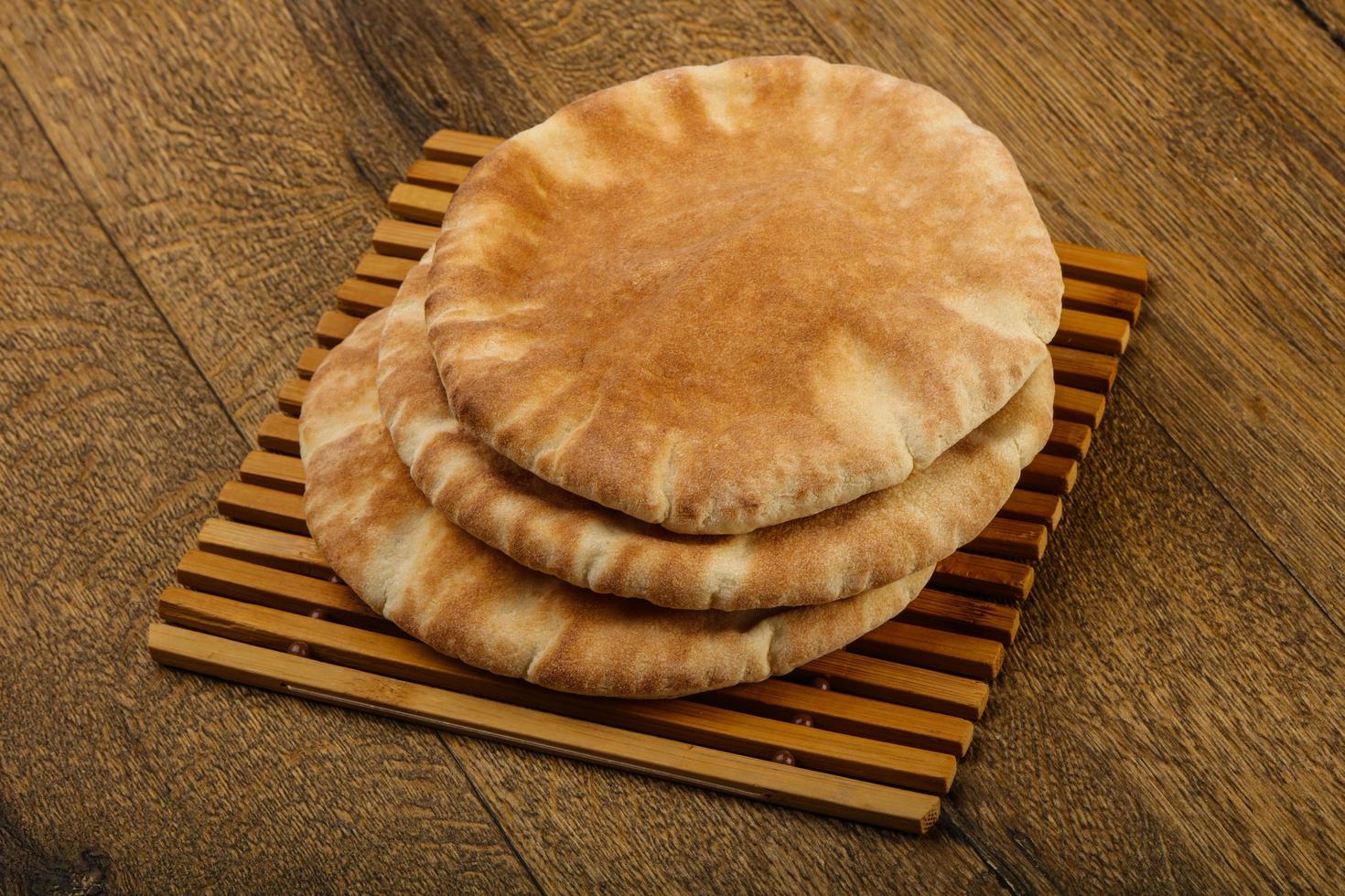 pita brood Aan houten bord en houten achtergrond foto